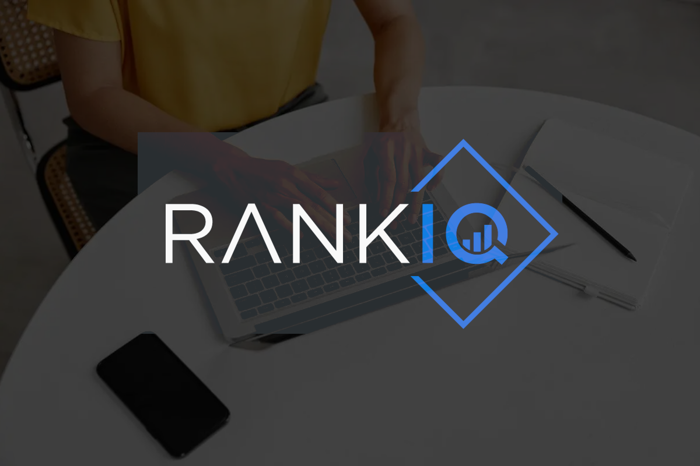 A person is typing on a laptop sitting on a table with the brand logo overlaid.