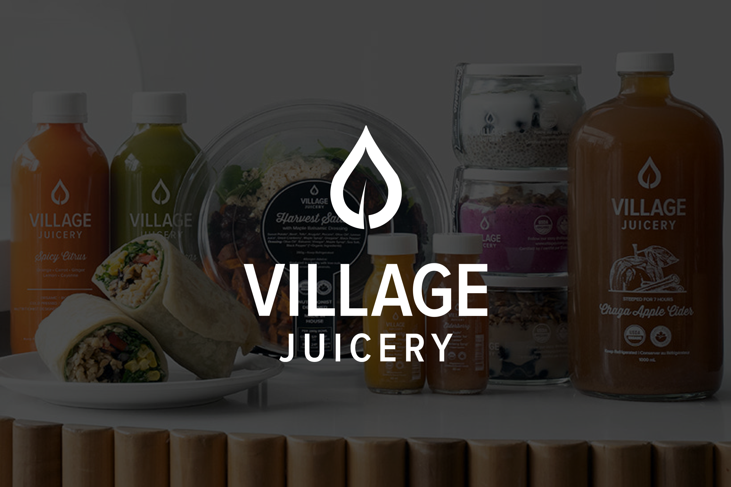Village Juicery branded juices, wraps, salads, and wellness shots displayed with logo overlayed.