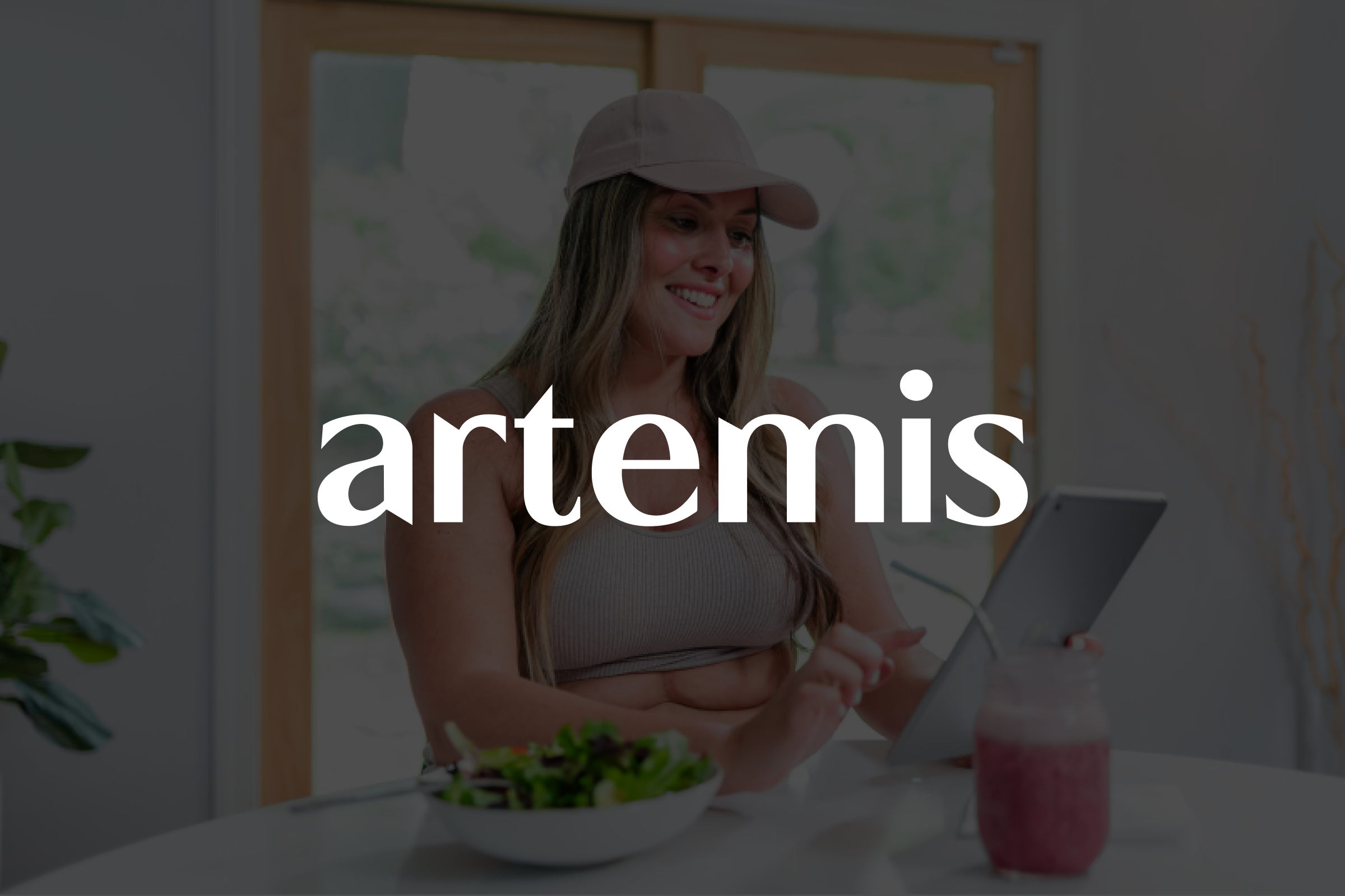 A person scrolling on their tablet and sitting on the kitchen table with the brand logo overlaid.